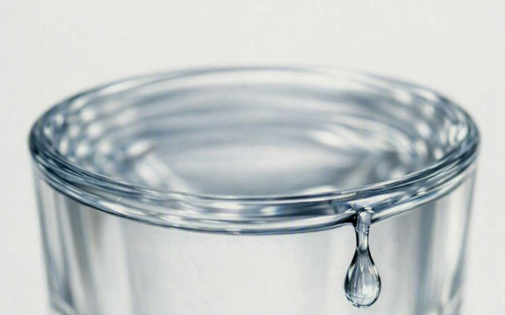 Close-up of a water glass with one drop on the rim